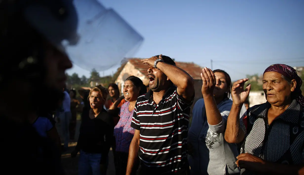 Beberapa warga pinggiran kota Roma, Stara Zagora, Bulgaria, hanya pasrah melihat tempat tinggalnya dihancurkan karena dianggap ilegal, (21/7/2014). (REUTERS/Stoyan Nenov)