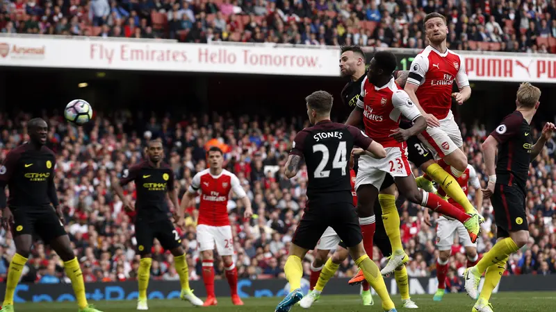 Bek Arsenal Shkodran Mustafi (dua dari kanan) menanduk bola untuk merobek gawang Manchester City pada duel di Emirates Stadium, Minggu (2/4/2017). 