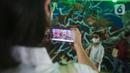 Warga berpose dengan latar belakang mural kolaborasi di Terowongan Kendal, Kawasan TOD Dukuh Atas, Jakarta, Rabu (6/7/2022). Karya seni mural yang terinspirasi dari film Marvel Studios "Thor: Love and Thunder" itu memanfaatkan teknologi augmented reality (AR). (Liputan6.com/Faizal Fanani)