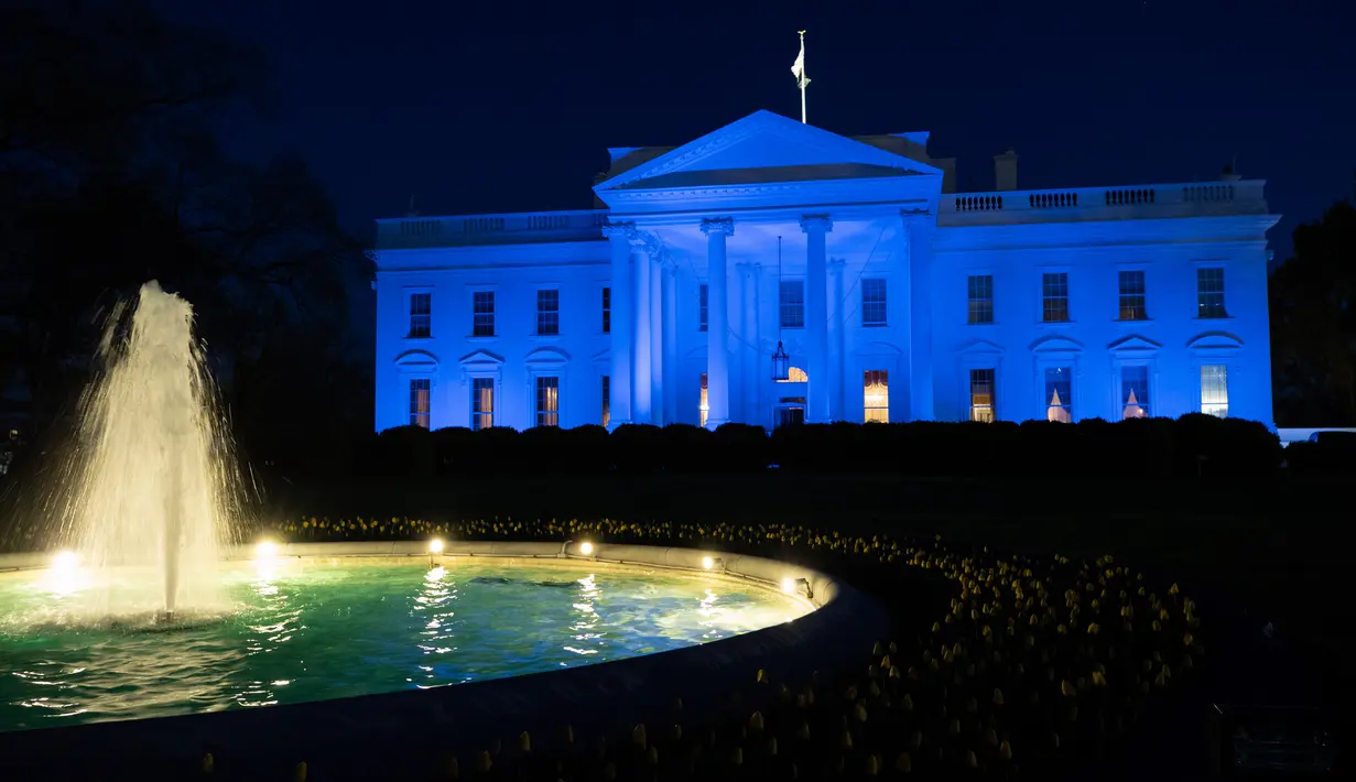 Gedung Putih diterangi dengan cahaya warna biru untuk menarik perhatian pada World Autism Awareness Day atau Hari Peduli Autisme Sedunia di Washington, Kamis (2/4/2020). Hari Peduli Autisme Sedunia jatuh setiap 2 April semenjak ditetapkan melalui sebuah resolusi PBB di tahun 2007. (AP/Alex Brandon)