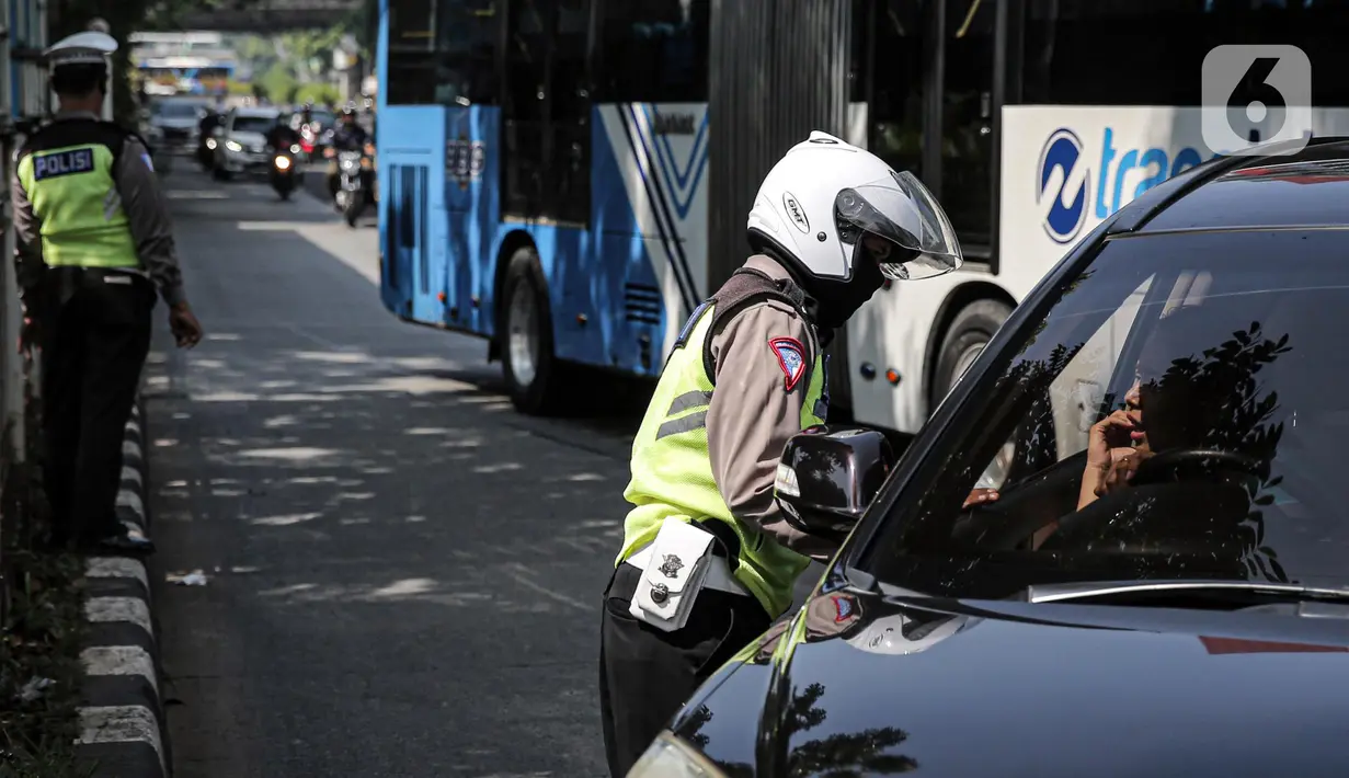 Polisi lalu lintas berkomunikasi dengan pengendara mobil saat Operasi Zebra Jaya 2022 di Jakarta, Selasa (4/10/2022). Operasi Zebra Jaya dilaksanakan pada tanggal 3 hingga 17 Oktober untuk menekan jumlah pelanggaran lalu lintas. (Liputan6.com/Faizal Fanani)