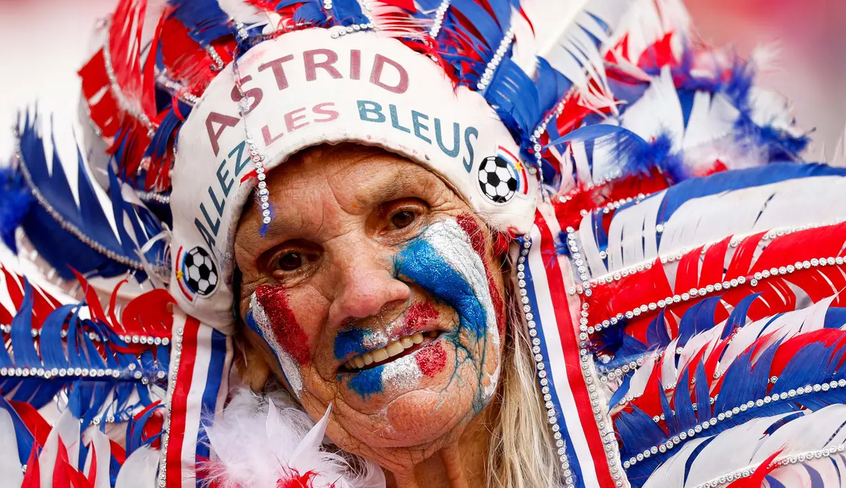 Seorang penggemar Prancis yang berdandan dan dirias berpose sebelum pertandingan sepak bola Grup D Euro 2024 antara timnas Belanda dan Prancis di Stadion Leipzig, Jerman, pada 21 Juni 2024. (Odd ANDERSEN/AFP)