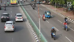 Sejumlah pengendara melintas dibawah kabel yang ditopang tiang bambu di kawasan Pasar Baru, Jakarta, Selasa (12/9). Selain membahayakan pengguna jalan, buruknya instalasi kabel tersebut juga merusak estetika kota. (Liputan6.com/Immanuel Antonius)