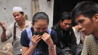 Seorang ibu tampak bersedih saat mengikuti doa bersama jelang penertiban permukiman Kampung Akuarium, Penjaringan, Jakarta, Senin (11/4). Mereka berdoa dengan khusuk di antara gang sempit, dengan menggelar terpal. (Liputan6.com/Gempur M Surya)