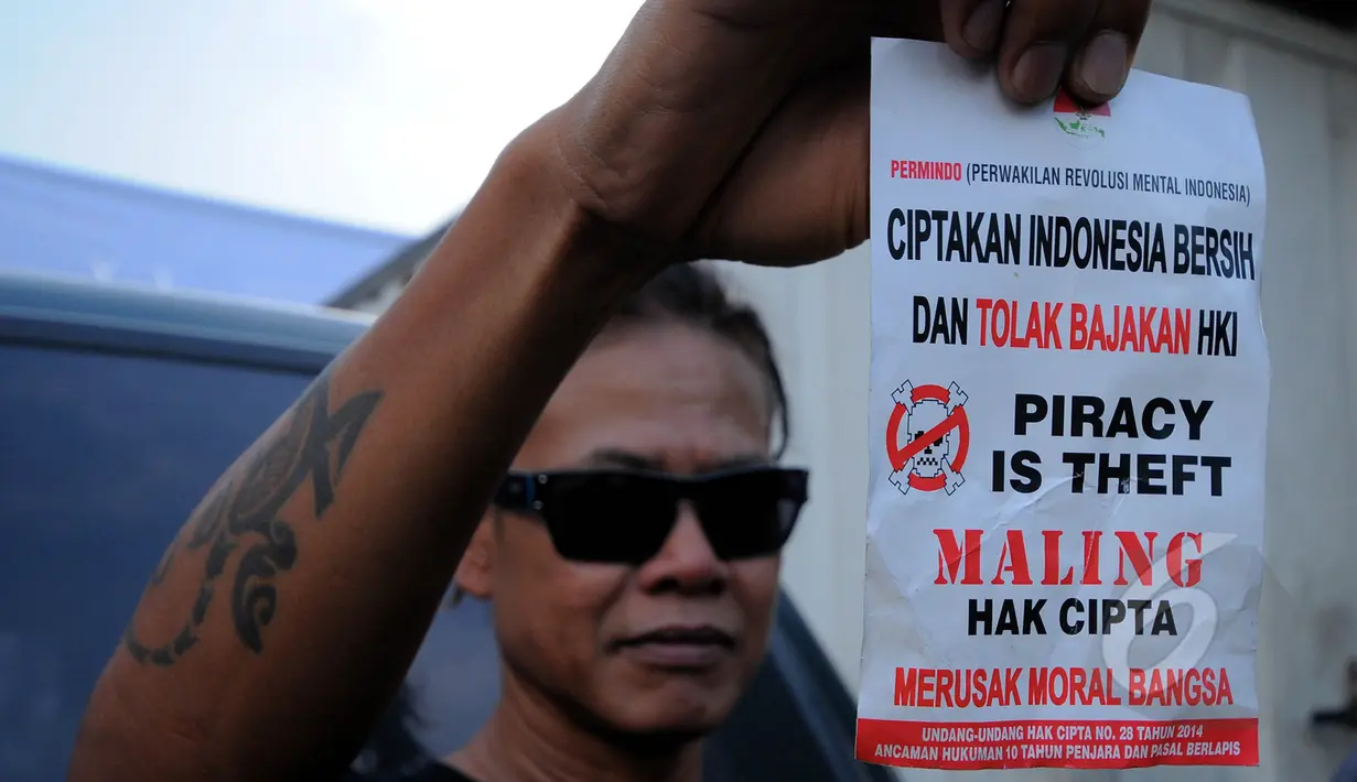 Tony Q Rastafara memperlihatkan sebuah selebaran yang berisi tolak pembajakan saat menghadiri konser 'MUSIK INDONESIA ASYIK TANPA INTRIK' dengan tema "AKULAH SEJARAH", Jakarta, Selasa (10/3/2015). (Liputan6.com/Faisal R Syam)