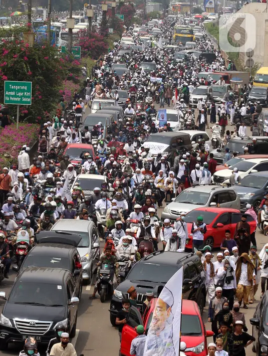 Ratusan massa berkonvoi mengawal Rizieq Shihab usai tiba di Bandara Soekarno-Hatta, Tangerang, Banten, Selasa (10/11/2020). Konvoi tersebut dilakukan untuk mengawal perjalan Rizieq Shihab menuju kediamannya di Petamburan, Jakarta. (Liputan6.com/Angga Yuniar)