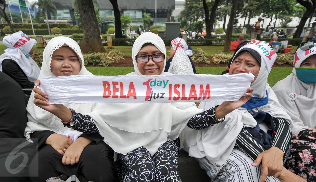 Demonstran perempuan menunjukkan spanduk saat aksi damai di pinggir taman Jalab Medan Merdeka Selatan, Jumat (4/11). Ratusan ribu massa aksi damai melakukan aksi menuntut penegakan hukum kasus dugaan penistaan agama. (Liputan6.com/Yoppy Renato)