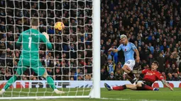 Striker Manchester City, Sergio Aguero melepaskan tendangan ke arah kiper MU, David De Gea saat bertanding pada lanjutan Liga Inggrid di stadion Etihad, Manchester (11/11). Sebelumnya, rambut Aguero berwarna hitam biasa. (AFP Photo/Lindsey Parnaby)