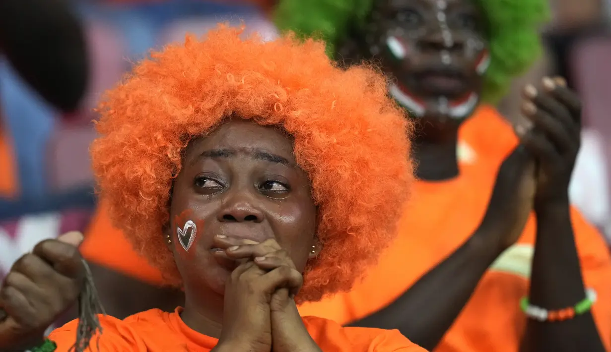 Reaksi supporter Pantai Gading di akhir adu penalti babak 16 besar Piala Afrika 2022 antara timnya dan Mesir di Stade Omnisport de Douala, Rabu (26/1/2022). Mesir melangkah ke perempat final setelah menyingkirkan Pantai Gading lewat drama adu penalti dengan skor 5-4 (0-0). (AP Photo/Themba Hadebe)