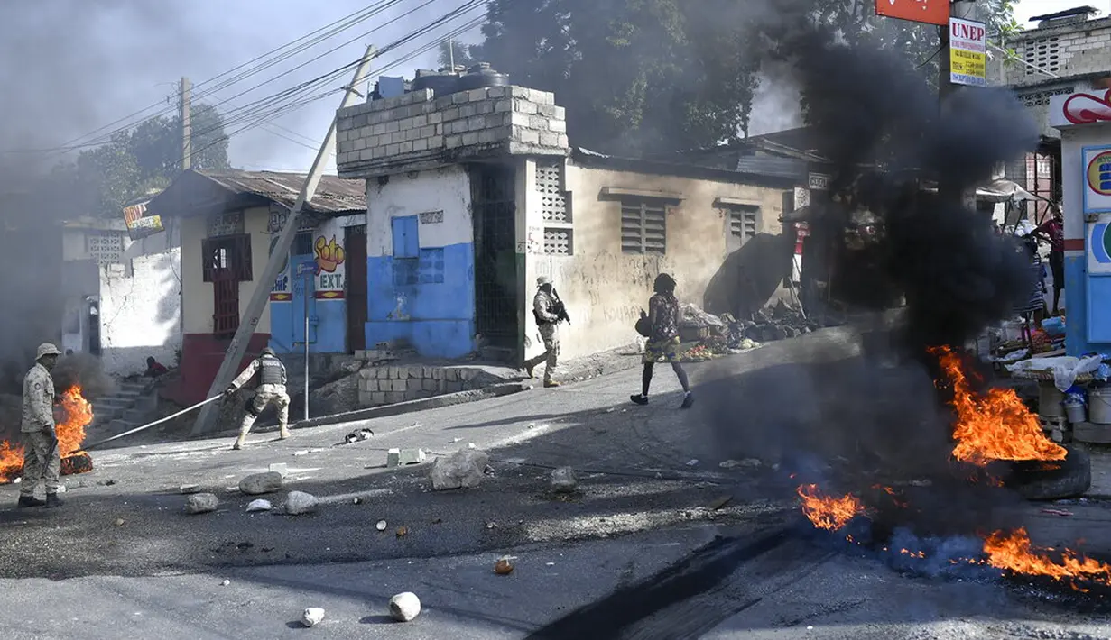 Ban terbakar setelah dibakar oleh pengunjuk rasa yang kesal dengan meningkatnya kekerasan di lingkungan Lalue, Port-au-Prince, Haiti, Rabu (14/7/2021). Presiden Haiti Jovenel Moise dibunuh pada 7 Juli. (AP Photo/Matias Delacroix)