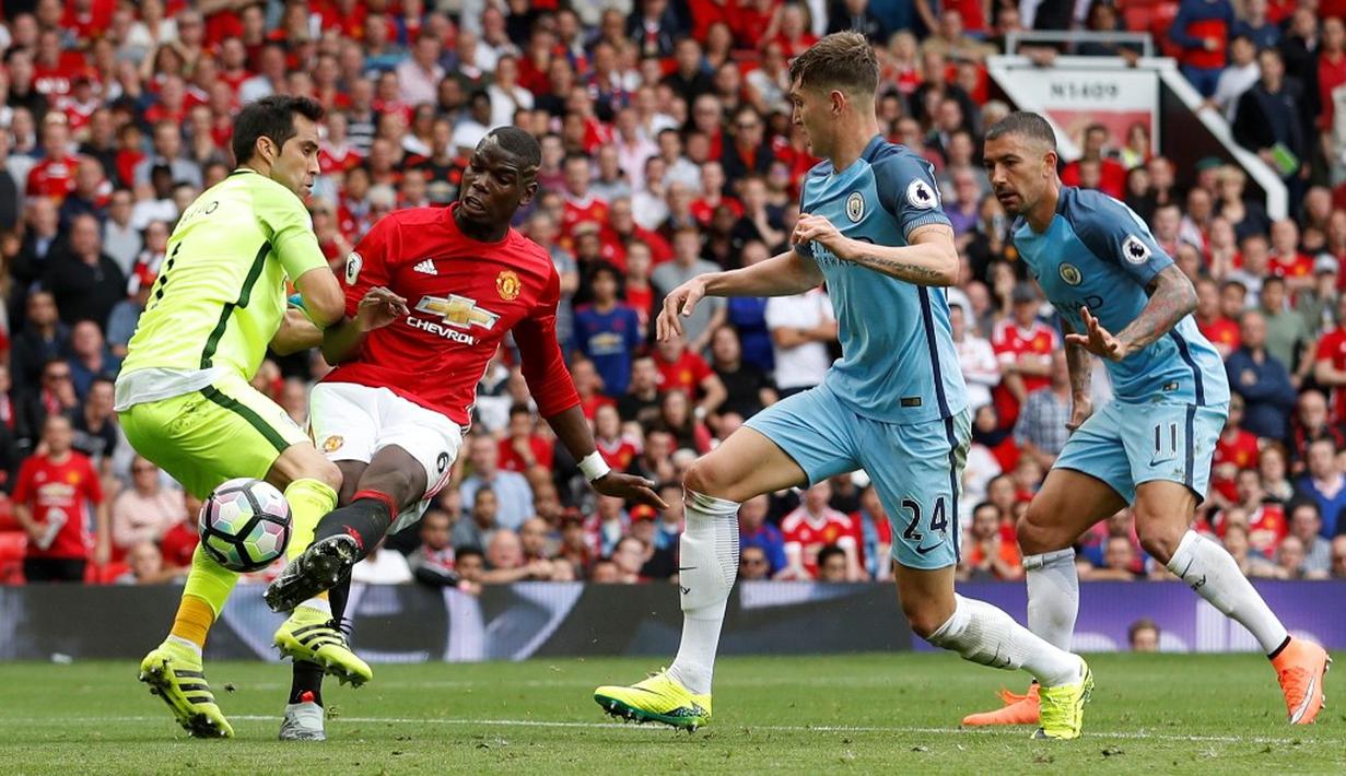 Kiper Manchester City, Claudio Bravo, berusaha menghalau bola tendangan pemain MU, Paul Pogba, dalam laga Premier League di Stadion Old Trafford, Sabtu (10/9/2016). (Action Images via Reuters/Carl Recine)