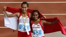 Selebrasi putri Indonesia, Rini Budiarti (kiri) yang meraih medali perak dan Triyaningsih meraih emas nomor lari 5.000m SEA Games 2015. (Bola.com/Arief Bagus)