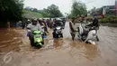 Sejumlah pengendara motor berusaha menerobos banjir di Jalan Raya Kalimalang, Caman, Bekasi, Senin (20/2). Banjir setinggi 80 cm itu disebabkan drainase buruk dan diperparah tingginya intensitas curah hujan. (Liputan6.com/Gempur M Surya)