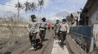 Polisi dengan anjing pelacak saat pencarian korban letusan Gunung Semeru selama pencarian korban di Lumajang, Jawa Timur, Rabu (8/12/2021). Berdasarkan laporan BNPB, jumlah korban meninggal hingga Rabu pukul 10.30 WIB hari ini berjumlah 41 orang dan 12 lainnya dalam pencarian. (AP Photo/Trisnadi)