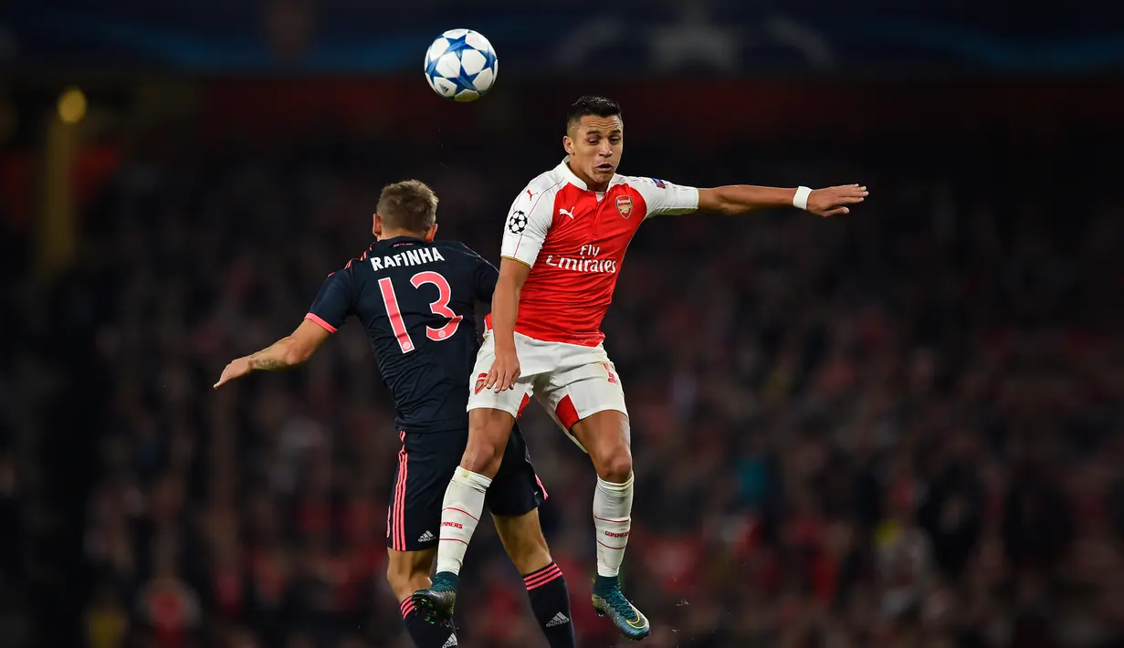 Penyerang Arsenal, Alexis Sanchez (kanan) berebut bola udara dengan bek Muenchen, Rafinha pada pertandingan liga Champions di Emirates Stadium, London, Inggris  (20/10/15). Arsenal menang atas Muenchen dengan skor 2-0. (Reuters/Dylan Martinez)