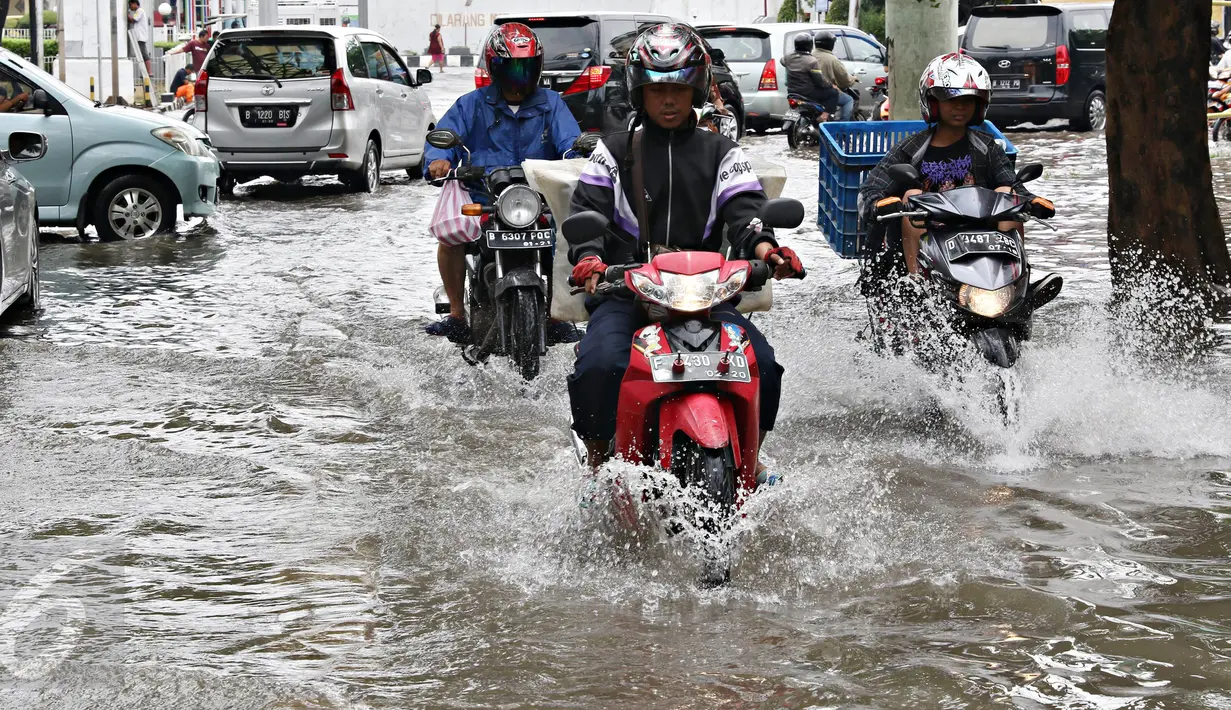 Kendaraan melewati banjir yang merendam Jalan Panjang, Jakarta Barat, Jumat (26/2). Hujan yang mengguyur wilayah Jakarta membuat sejumlah titik terendam banjir hingga ketinggian sekitar 20 cm hingga 1 meter. (Liputan6.com/ Immanuel Antonius)