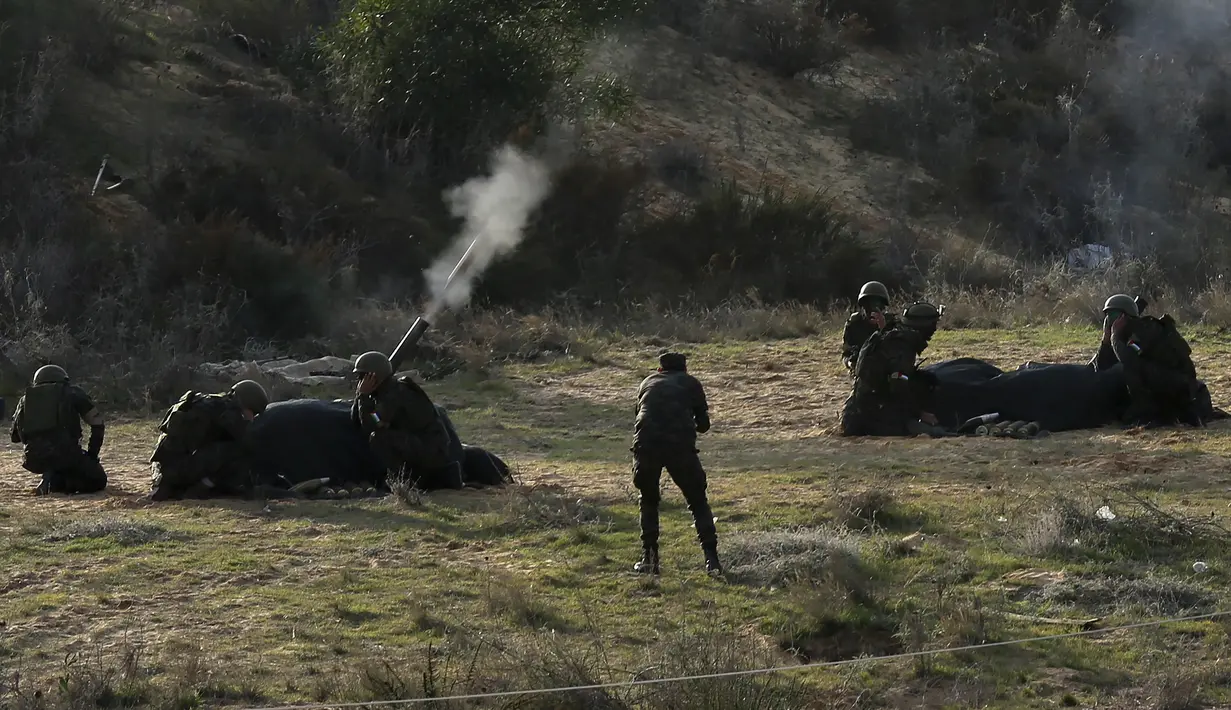 Militan Palestina menembak saat latihan militer yang diselenggarakan oleh faksi militer di Rafah, Jalur Gaza selatan, Rabu (29/12/2021). (AP Photo/Adel Hana)