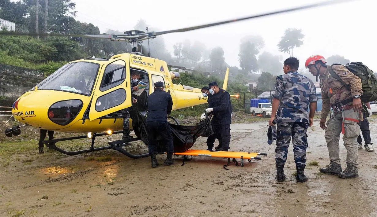 Personel kepolisian Nepal yang membawa jenazah korban banjir turun dari helikopter saat operasi penyelamatan di Dhunche Bazaar, distrik Rasuwa, Nepal, Senin, 31 Agustus 2026. (AFP/ Prabin Ranabhat)
