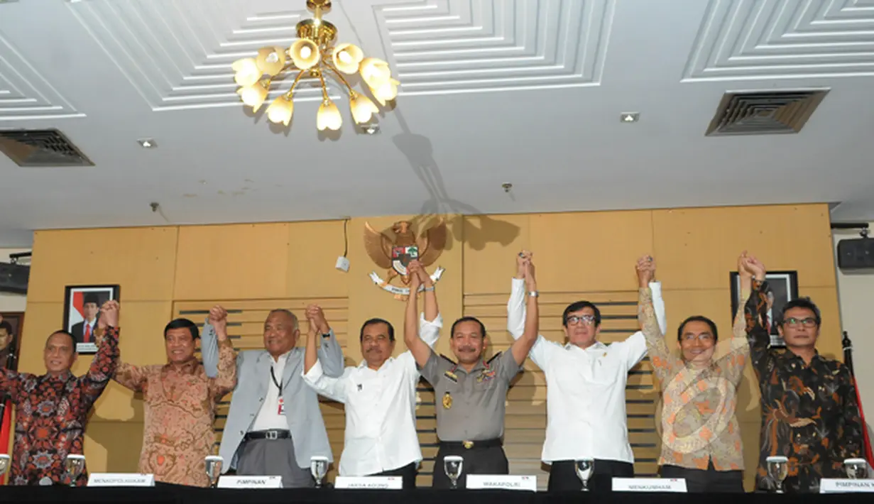 Pimpinan KPK bersama sejumlah menteri dan petinggi lembaga hukum mengangkat tangan usai melakukan pertemuan dan jumpa pers di Gedung KPK, Senin (2/3/2015).  (Liputan6.com/Herman Zakharia)