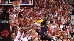 LeBron James #23 melakukan dunk fmelewati hadangan pemain Raptors, Bismack Biyombo #8 pada laga final wilayah timur NBA playoffs 2016 di Air Canada Centrer (27/5/2016). Cavaliers menang 113-87.  (Dan Hamilton-USA TODAY Sports)