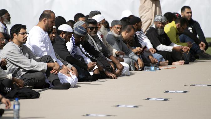 Umat muslim menghadiri pelaksanaan salat Jumat di Hagley Park, Kota Christchurch, Selandia Baru, Jumat (22/3). Salat Jumat digelar di seberang Masjid Al Noor yang menjadi salah satu lokasi insiden teror pada 15 Maret lalu. (Marty MELVILLE / AFP)