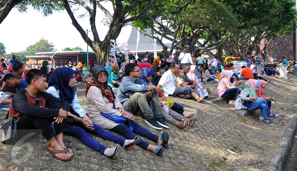 Sejumlah pengunjung beristirahat di area wisata Taman Mini Indonesia Indah, Jakarta, Minggu (19/07/2015). Makan bersama sambil menggelar tiker di tempat wisata menjadi pilihan warga yang mengunjungi tempat wisata TMII. (Liputan6.com/Yoppy Renato)