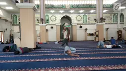 Seorang pria melintas di antara jemaah yang sedang tidur-tiduran di Masjid Agung Baiturrahim, Provinsi Gorontalo, Sabtu (11/5/2019). Sebagian umat muslim menghabiskan waktu dengan tidur di masjid atau melakukan tadarus Alquran pada siang hari selama bulan Ramadan. (Liputan6.com/Arfandi Ibrahim)
