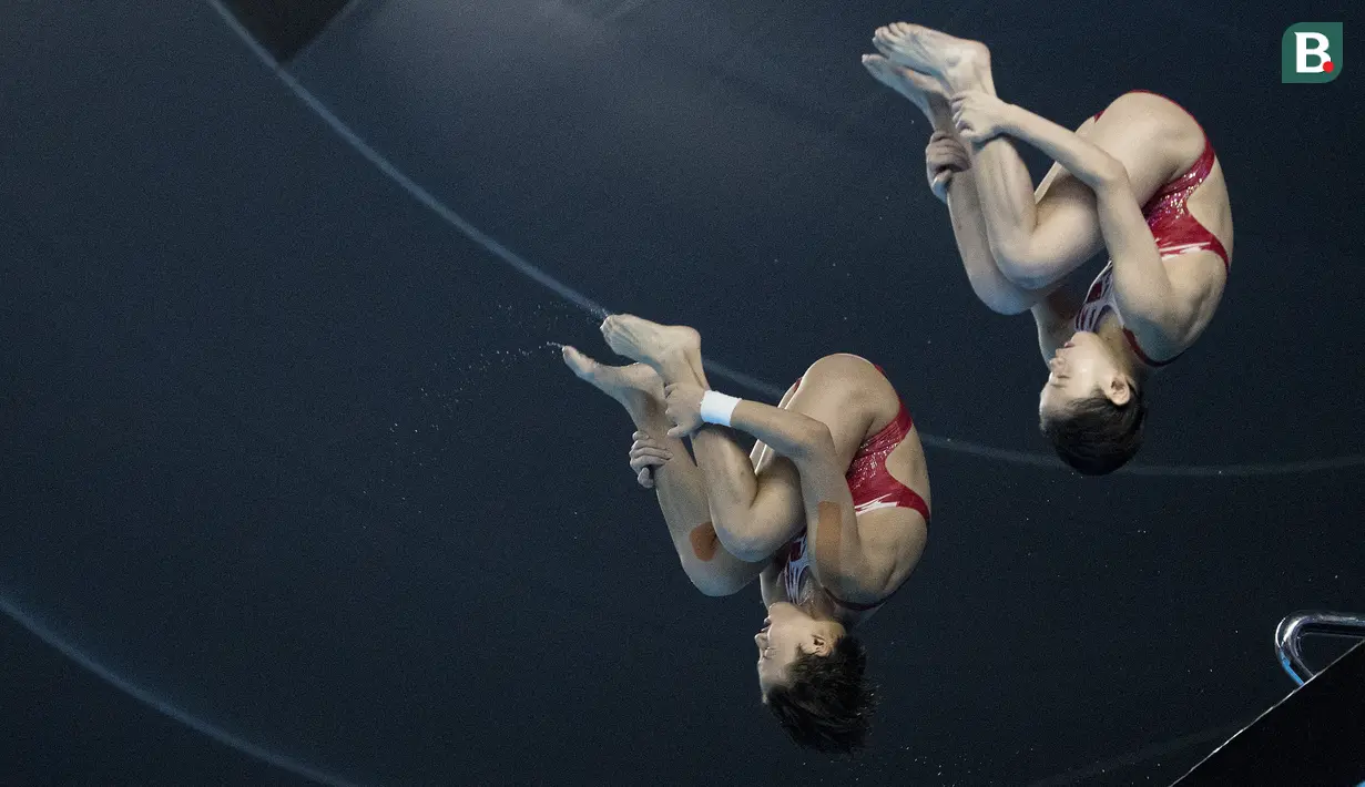 Aksi Zhang Jiaqie dan Zhang Minjie pasangan peloncat indah asal China yang meraih medali emas di nomor papan 10 meter sinkronisasi pada Asian Games 2018 di Stadion Akuatik, Gelora Bung Karno Senayan Jakarta, Selasa (28/8/2018). (Bola.com/Peksi Cahyo)