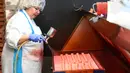 Pekerja memberi warna pada kue yang terbuat dari marzipan segar di tempat pembuatan tradisional JG Niederegger GmbH di Luebeck, Jerman (5/12). (AFP Photo/Stollarz)