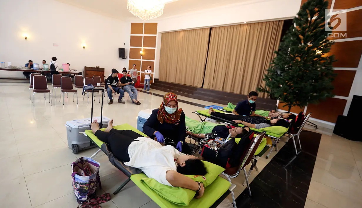 Petugas muslim dari Palang Merah Indonesia (PMI) membantu Jemaat Gereja Protestan Indonesia Bagian Barat (GPIB) dalam donor darah, Jakarta, Minggu (3/12). Kegiatan tersebut diadakan dalam rangkaian acara Natal. (Liputan6.com/JohanTallo)