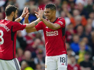 Pemain Manchester United, Bruno Fernandes (kiri) dan Casemiro, melakukan selebrasi setelah keduanya mencetak gol ke gawang Nottingham Forrest dalam pertandingan pekan ketiga Premier League 2023/2024 yang berlangsung di Old Trafford, Manchester, Inggris, Sabtu (26/8/2023). (AP Photo/Jon Super)