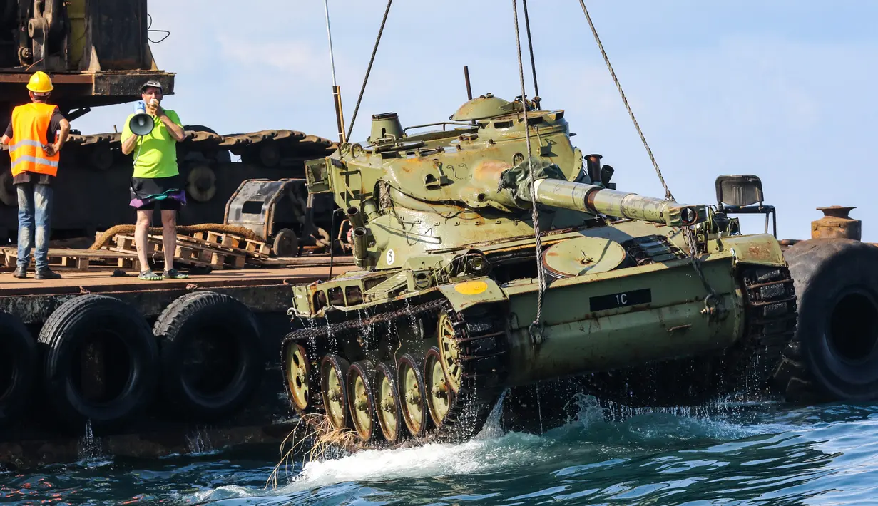 Aktivis lingkungan menenggelamkan sebuah tank lama ke dasar Laut Mediterania di lepas pantai kota pelabuhan Sidon, Lebanon, Sabtu (28/7). Penenggelaman ini diharapkan bisa menciptakan surga baru bagi satwa liar di Laut Mediterania. (AFP / Mahmoud ZAYYAT)