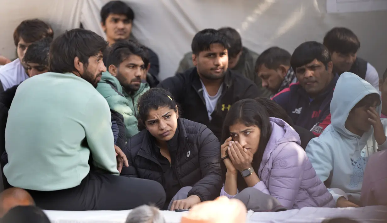 Sakshi Malik, pegulat India yang memenangkan medali perunggu di Olimpiade Musim Panas 2016, (kedua kiri) dan Bajrang Punia, yang memenangkan medali Perunggu di Olimpiade Tokyo 2020 (kiri) berpartisipasi dengan pegulat lain dalam protes terhadap Presiden Federasi Gulat India Brijbhushan Sharan Singh dan pejabat lainnya di New Delhi, India, Jumat (20/1/2023). Pegulat top India memimpin protes di dekat gedung parlemen menuduh presiden federasi dan pelatih melakukan pelecehan seksual dan mental terhadap pegulat muda. (AP Photo/Manish Swarup)