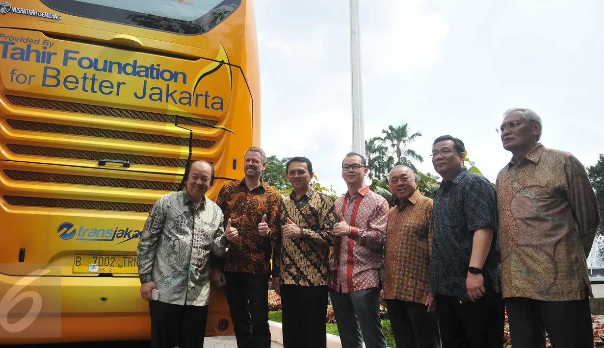 Gubernur DKI Jakarta, Basuki T Purnama (ketiga kiri) dan Chairman Mayapada Group, Dato Sri Tahir (kiri) bersama pejabat terkait saat foto bersama dibelakang bus tingkat dari Tahir Foundation, (17/6). (Liputan6.com/Gempu M Surya)