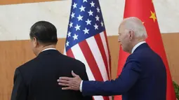 Presiden AS Joe Biden berjalan dengan Presiden China Xi Jinping sebelum pertemuan di sela-sela pertemuan puncak G20 di Nusa Dua, di Bali, Senin (14/11/2022). Pertemuan ini menjadi catatan sejarah di tengah panas dingin hubungan Amerika Serikat dan China. (AP/Alex Brandon)