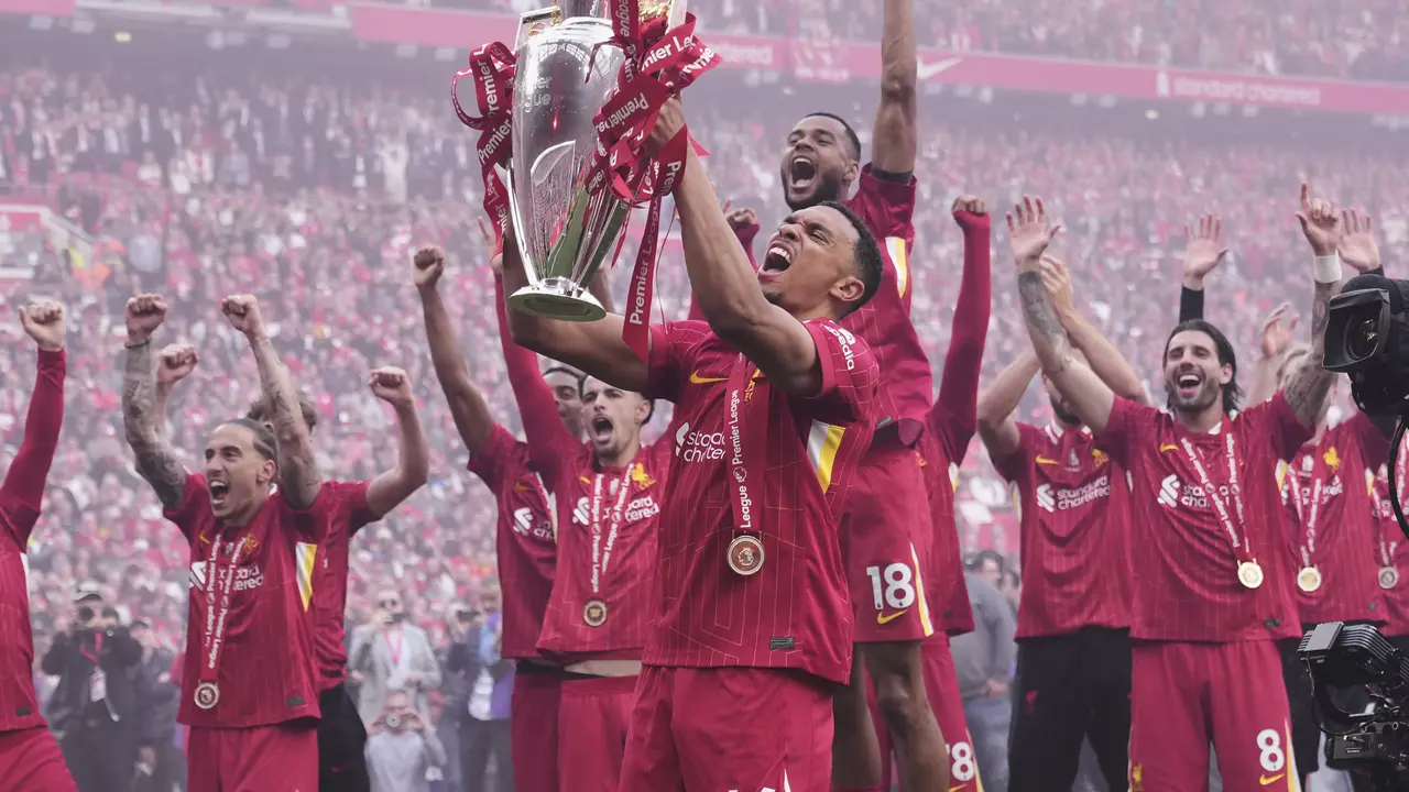 Trent Alexander-Arnold mengangkat trofi Premier League 2024/2025 usai laga Liverpool vs Crystal Palace, Minggu (25/05/2025). (AP/Jon Super)