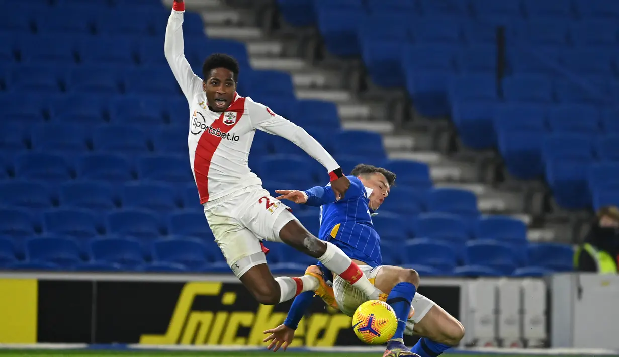 Bek Southampton, Kyle Walker-Peters, berebut bola dengan gelandang Brighton, Solly March, pada laga lanjutan Liga Inggris di Falmer Stadium, Selasa (8/12/2020) dini hari WIB. Southampton menang 2-1 atas Brighton. (AFP/Mike Hewitt/pool)