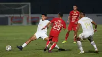 Pemain Persija Jakarta, Riko Simanjuntak (tengah) berusaha melewati pemain Dewa United, Theo Fillo Numberi dalam laga pekan ke-16 BRI Liga 1 2022/2023 di Stadion Sultan Agung, Bantul, Yogyakarta, Selasa (20/12/2022) malam WIB. (Bola.com/Ikhwan Yanuar)