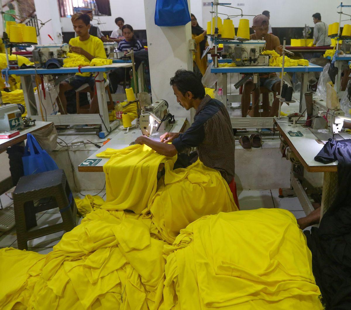 Sejumlah pekerja menjahit kain yang telah disablon saat menyelesaikan pesanan kaos di perusahaan konfeksi Sinergi Adv, kawasan Srengseng Sawah, Jakarta, Selasa (2/7/2024). Kenaikan nilai mata uang dolar Amerika Serikat (AS) terhadap Rupiah hingga minurunn