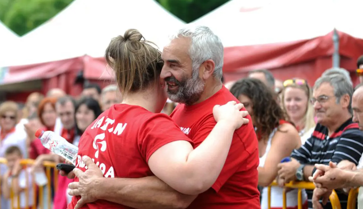 Nerea Sorondo (kiri) mendapat ucapan selamat dari sang pelatih usai memotong batang pohon di kejuaraan olahraga pedesaan di festival San Fermin yang dihelat di Pamplona, Spanyol Utara, (8/7/2014). (AFP PHOTO/Ander Gillenea)