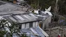 Tim penyelamat berada di lokasi jatuhnya pesawat kecil di tengah-tengah rumah penduduk di Popayan, Kolombia, Minggu (15/9/2019). Otoritas setempat sedang menyelidiki penyebab dari kecelakaan pesawat yang jatuh beberapa menit setelah lepas landas dari bandara Popayan. (Luis ROBAYO / AFP)