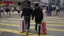 Sepasang suami istri membawa persediaan tisu toilet di sebuah jalan pada Hari Valentine di Hong Kong, Jumat, (14/2/2020). Hari Valentine pada tanggal 14 Februari adalah sebuah hari di mana para kekasih dan mereka yang sedang jatuh cinta menyatakan cintanya. (AP Photo/Kin Cheung)