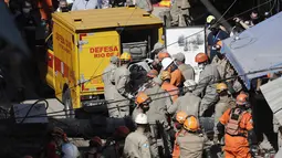 Petugas pemadam kebakaran menempatkan ke dalam kendaraan Pertahanan Sipil, tubuh ditemukan dari sebuah bangunan empat lantai yang runtuh semalam di daerah kumuh Rio das Pedras Rio de Janeiro, Brasil (3/6/2021). (AP Photo/Bruna Prado)