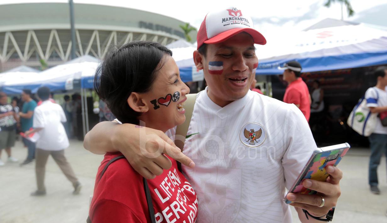 Suporter dengan  wajah penuh warna Merah-Putih hadir memberi dukungan saat Timnas Indonesia melawan Thailand pada laga AFF Suzuki Cup 2016 di Philippine Sports Stadium, (19/11/2016).  (Bola.com/Nicklas Hanoatubun)