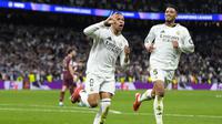 Bomber Real Madrid, Kylian Mbappe, merayakan hattrick yang dicetaknya ke gawang Man City bersama rekan setimnya, Jude Bellingham, dalam pertandingan leg kedua play-off 16 besar Liga Champions yang berlangsung di Santiago Bernabeu, Kamis (20/2/2025) dini hari WIB. Real Madrid menang 3-1 atas Man City dan lolos ke 16 besar Liga Champions dengan kemenangan agregat 6-3. (AP Photo/Manu Fernandez)