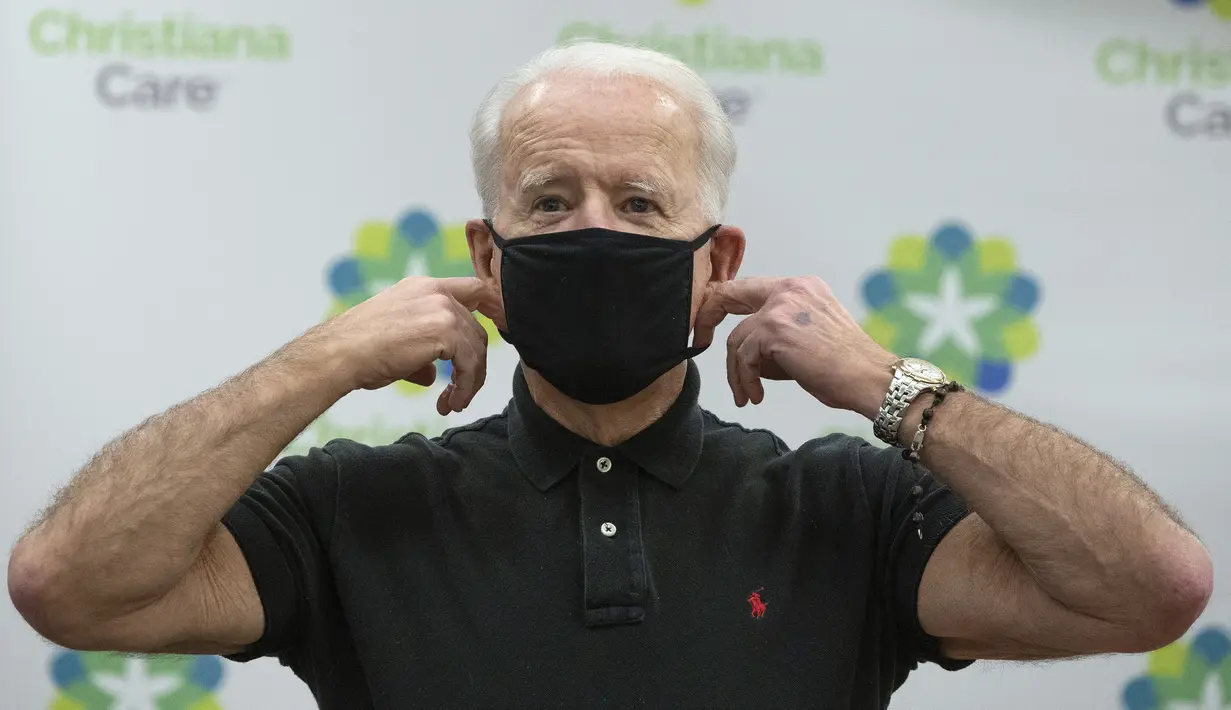 Presiden terpilih Amerika Serikat, Joe Biden merapikan masker usai menerima dosis kedua vaksin COVID-19 Pfizer di Rumah Sakit Christiana di Newark, Delaware, Senin (11/1/2021). Sebelumnya, Biden mendapat suntikan pertamanya pada 21 Desember 2020 lalu. (Alex Wong/Getty Images/AFP)