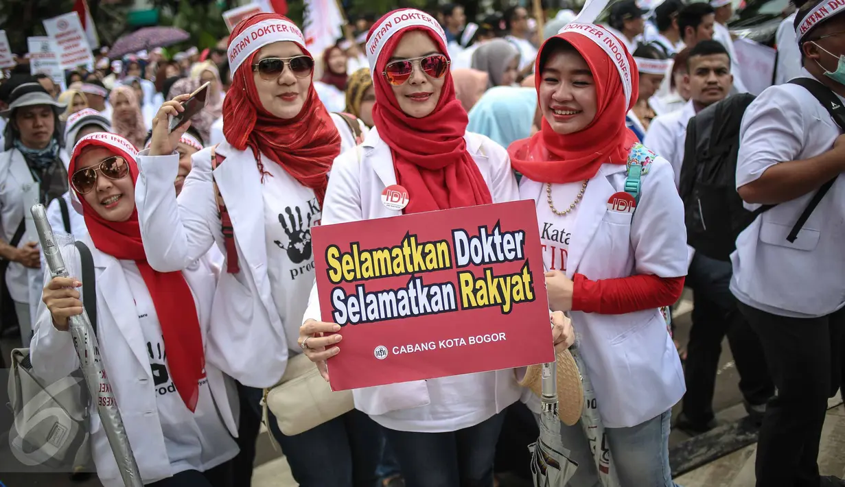 Sejumlah dokter memperlihatkan poster tuntutan saat melakukan aksi unjuk rasa di Ibu Kota hari ini, Senin (24/10). Demo itu untuk menuntut pemerintah agar membatalkan Program Dokter Layanan Primer (DLP). (Liputan6.com/Faizal Fanani)
