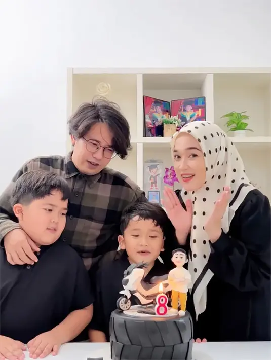 Kue ulang tahun warna hitam seperti ban warna hitam. Diatas terdapat angka 8, hiasan motor dan  boneka anak laki-laki sebagai topping-nya. [Instagram/ririe_fairus]