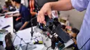 Profesor Viboon Sangveraphunsiri memegang komponen lensa kamera robot medis yang dimodifikasi untuk memeriksa pasien virus corona COVID-19 di Regional Center of Robotics Technology, Chulalongkorn University, Bangkok, Thailand, Rabu (18/3/2020). (LILLIAN SUWANRUMPHA/AFP)