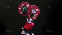 Syarah Anggraini menahan beban saat turun pada kelas 53 kg di Hall A Arena PRJ, Jakarta, Rabu (11/2/2018). Syarah meraih medali perak pada nomor tersebut dengan total angkatan 180 kg. (Bola.com/Nicklas Hanoatubun)